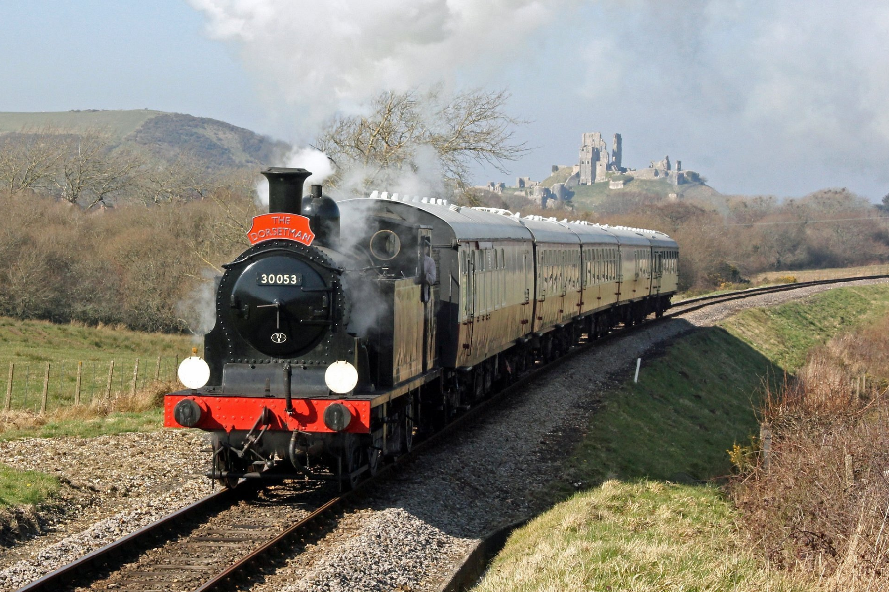 The Dorsetman steam train chugs along the scenic countryside near Corfe Castle.